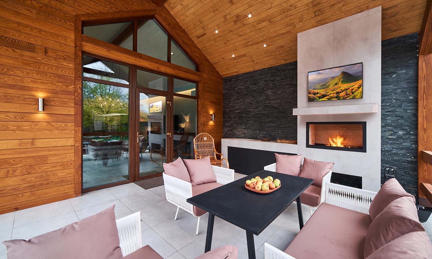 outdoor dining table in front of fireplace and TV display
