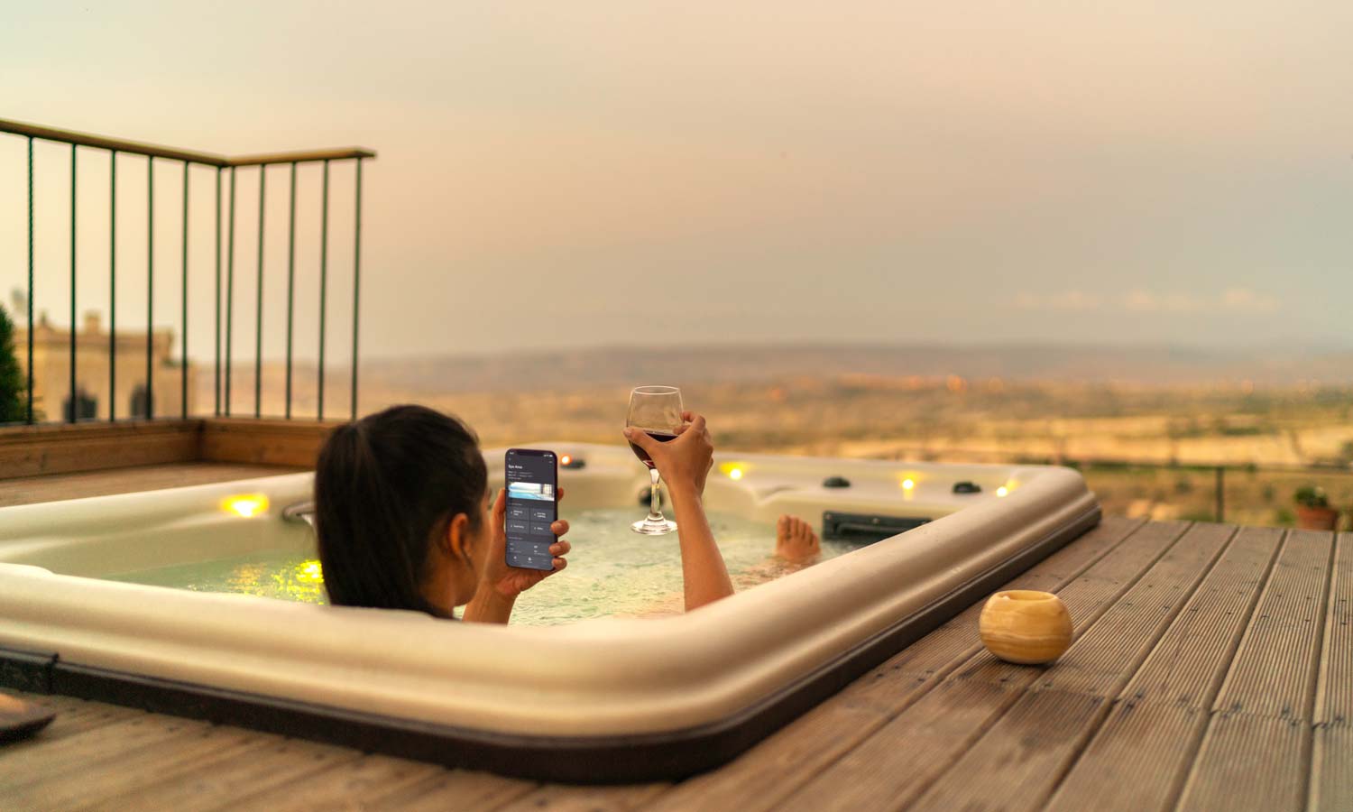 woman sits in hot tub on a patio
