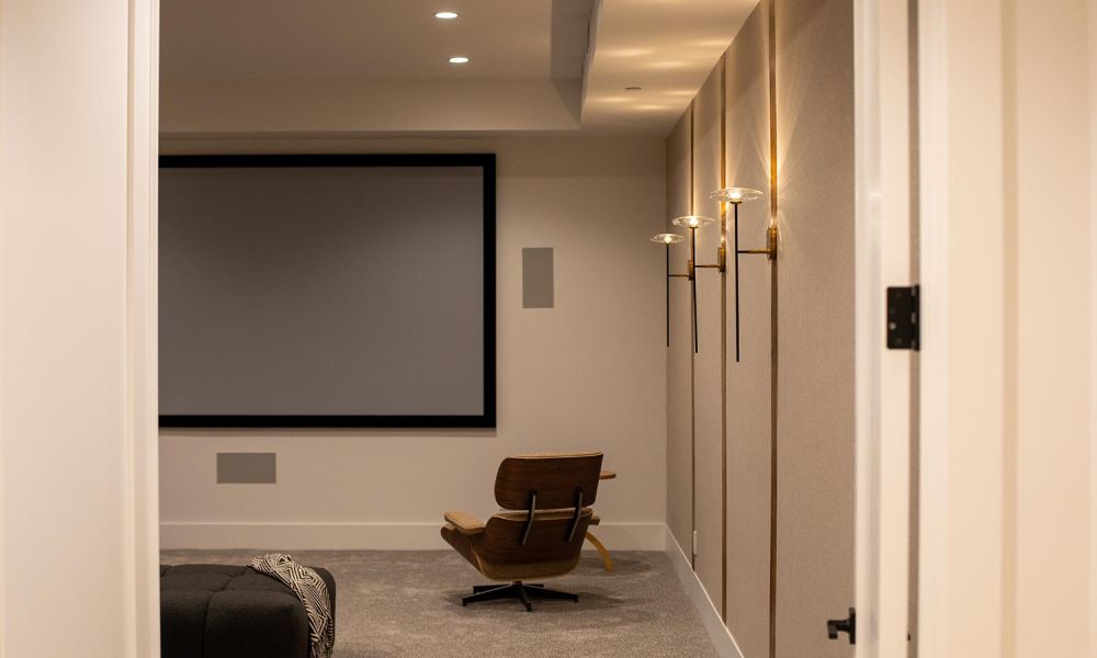Full room view of a minimalist home theater with dim wall lighting