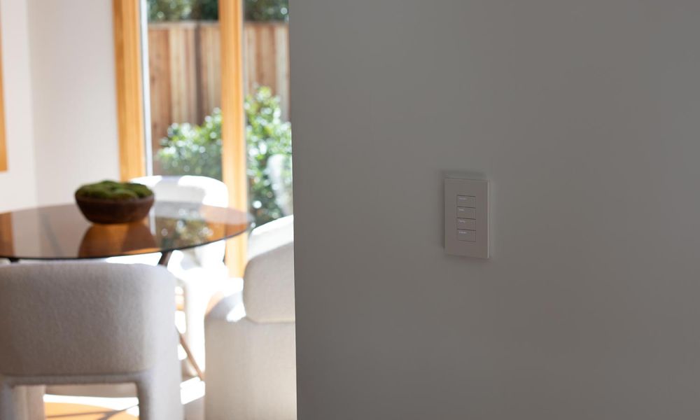 Smart light switch near a dining area with natural lighting